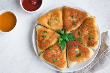 Derin kızarmış etli turtalar soslar, samsa, samosas, echpochmak - geleneksel et dolması turta ya da vejetaryen kekler beyaz zemin üzerine, kopya alanı.