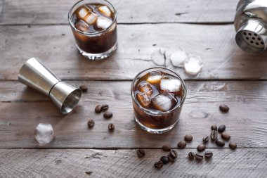 Siyah Rus kokteyl votka ve kahve likörü ile. Ev yapımı alkol ayyaş siyah Rus iç ahşap zemin kopya alanı üzerine kahve çekirdekleri ile.