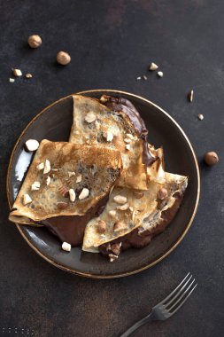 Krep çikolata yayıldı ve fındık ile. Kahvaltı veya tatlı rustik arka planda, kopya alanı için ev yapımı ince krep.