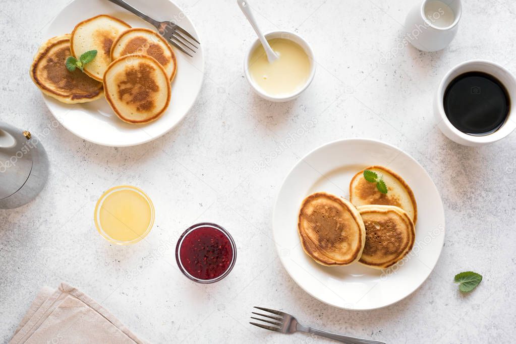 Pancakes for breakfast. Homemade pancakes with various toppings, jam, honey and coffee - breakfast for two, weekend family breakfast, top view.