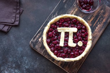 Kirazlı turta - Pi ile ev yapımı geleneksel kiraz pasta yapma imzalamak için Mart 14th tatile ahşap arka plan, üstten görünüm gün pi.