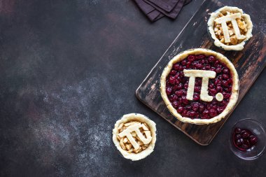 Gün kiraz ve elmalı turta - ev yapımı yapım pi geleneksel Mart için Pi işareti ile çeşitli börek 14 tatile rustik arka plan, üstten görünüm, kopyalama alanı.