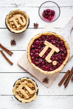 Gün kiraz ve elmalı turta - ev yapımı yapım pi geleneksel Mart için Pi işareti ile çeşitli börek 14 tatile Beyaz ahşap arka plan, görünümü top.