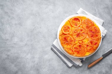 Ters alanı gri beton zemin üzerine turuncu kek aşağı kopyalayın. Ev yapımı kek ile kanlı portakal, narenciye.