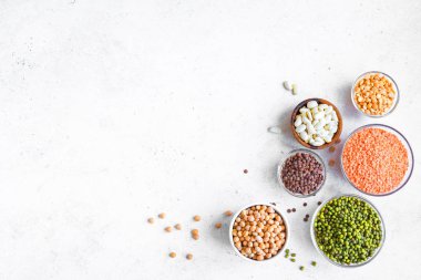 Kase, mercimek, barbunya fasulyesi, nohut, mung, bezelye beyaz arka planda, üstten görünüm, içinde renkli baklagiller ürün yelpazesine alanı kopyalayın. Sağlıklı gıda, diyet, beslenme kavramı, vegan protein kaynağı.