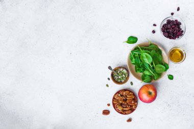 Sağlıklı salata sağlıklı vegan yemek salata - için malzemeler bebek ıspanak yaprakları, elma, pekan fındık, Kuru cranberries. Yeme temiz ya da gıda maddeleri beyaz arka plan, kopya alanı üzerinde diyet.