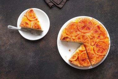 Ters alanı aşağı turuncu kek koyu arka plan üzerine kopyalayın. Ev yapımı kek ile kanlı portakal, narenciye.