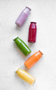 Çeşitli tatlılar veya suyu şişelerde, sağlıklı diyet Detoks vegan temiz gıda kavramı, üstten görünüm alanı kopyalayın. Beyaz arka plan üzerinde renkli smoothies.