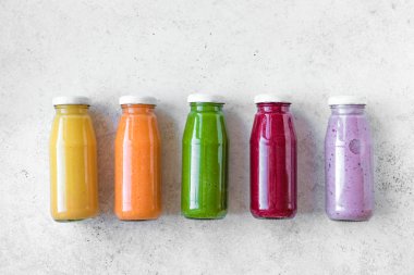 Çeşitli tatlılar veya suyu şişelerde, sağlıklı diyet Detoks vegan temiz gıda kavramı, üstten görünüm alanı kopyalayın. Beyaz arka plan üzerinde renkli smoothies.