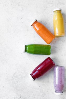 Çeşitli tatlılar veya suyu şişelerde, sağlıklı diyet Detoks vegan temiz gıda kavramı, üstten görünüm alanı kopyalayın. Beyaz arka plan üzerinde renkli smoothies.