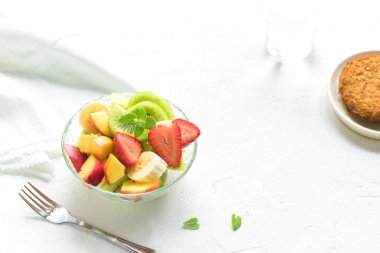 Sağlıklı kahvaltı veya aperatif için kase meyve salatası. Ham vejetaryen fitness gıda ve yaşam tarzı kavramı, beyaz arka plan kopya alanı ile diyet.