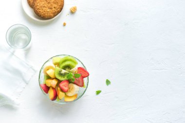 Sağlıklı kahvaltı veya aperatif için kase meyve salatası. Ham vejetaryen fitness gıda ve yaşam tarzı kavramı, beyaz arka plan kopya alanı ile diyet.