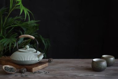 Çaydanlık ve Teacups siyah arka plan, kopya alanı üzerine. Çay töreni - demir demlik ve çay ile seramik çay bardaklarından için geleneksel Asya düzenleme.
