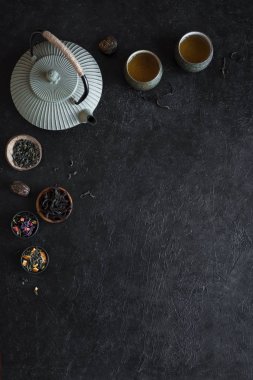 Çeşitli çay seçimi, çaydanlık ve Teacups siyah arka plan, kopya alanı üzerine. Geleneksel Asya çay aranjman - demir demlik ve çay ile seramik çay bardaklarından.