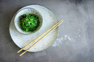 Chuka yosun salata üzerine beton arka plan, seramik kase alanı kopyalayın. Japon mutfağı - Chuka salata