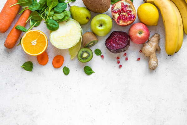 Colorful fruits and vegetables on a white table. Juice and smoothie ingredients. Healthy clean eating, detox, diet concept.