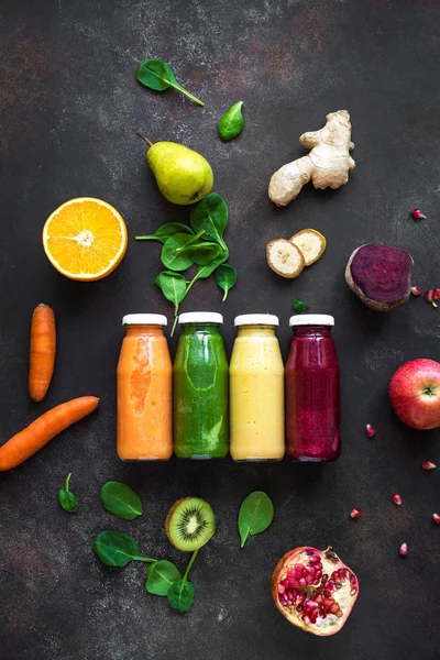 Çeşitli renkli smoothies veya şişe ve malzemelerin üzerine karanlık suları. Sağlıklı Diyet Detoks vegan temiz gıda kavramı, üstten görünüm.