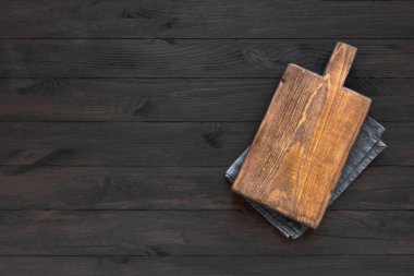 Siyah ahşap mutfak masasında boş tahta kesme tahtası, üst manzara, düz yatış. Tahta tabaklar, boşluğu kopyala.