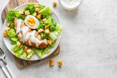 Beyaz arka planda tavuk göğsü olan Sezar salatası, üst manzara, kopyalama alanı. Sağlıklı öğle yemeği için taze tavuk salatası..