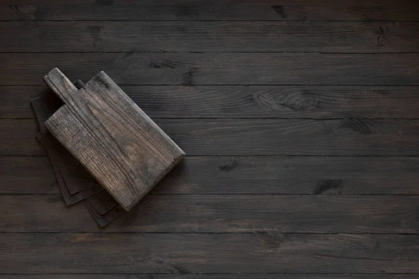 Pusty Drewniany Deska Krojenia Czarnym Drewnianym Stole Kuchennym Widok Góry — Zdjęcie stockowe