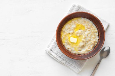 Beyaz masada tereyağlı yulaf lapası. Sağlıklı Yulaf ezmeli Kahvaltı, üst görünüm, kopyalama alanı.
