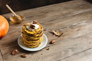 Krem şantili ve cevizli balkabaklı krep, kopyalama alanı. Geleneksel sonbahar sağlıklı kahvaltısı - balkabağı pankekleri.