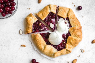 Beyaz üzerine badem ve vanilyalı dondurma sergilenen Cherry Galette, üst manzara, kopyalama alanı. Ev yapımı sağlıklı tatlı - vişneli turta ya da Fransız galeti.
