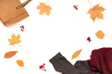 Sonbahar kompozisyonu - süet çanta, rahat atkı ve kazak, beyaz arka planda izole sonbahar yaprakları, düz döşeme, üst manzara, kopyalama alanı. Mevsimlik sonbahar konsepti.