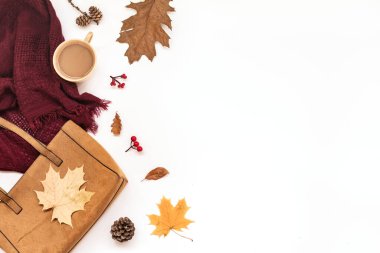 Sonbahar kompozisyonu - süet çanta, rahat eşarp, sonbahar yaprakları ve beyaz arka planda izole edilmiş kahve, düz yatak, üst manzara, kopyalama alanı. Mevsimlik sonbahar konsepti.
