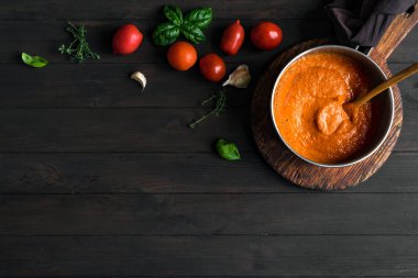 Ev yapımı domates sosu pişirme tavasında ve malzemeler kırsal ahşap masa, üst manzara, fotokopi alanı. Organik İtalyan domates sosu ya da çorbası yapıyorum..