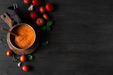 Ev yapımı domates sosu pişirme tavasında ve malzemeler kırsal ahşap masa, üst manzara, fotokopi alanı. Organik İtalyan domates sosu ya da çorbası yapıyorum..
