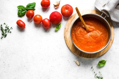 Yemek tavasında ev yapımı domates sosu ve beyaz masa, üst manzara, fotokopi alanı. Organik İtalyan domates sosu ya da çorbası yapıyorum..