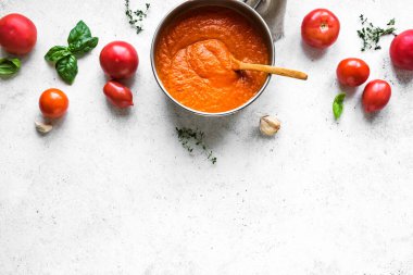 Yemek tavasında ev yapımı domates sosu ve beyaz masa, üst manzara, fotokopi alanı. Organik İtalyan domates sosu ya da çorbası yapıyorum..