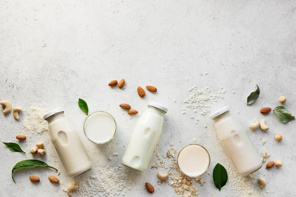 Vegan plant based milk and ingredients, top view, copy space. Various dairy free, lactose free nut and grains milk, substitute drink, healthy eating.