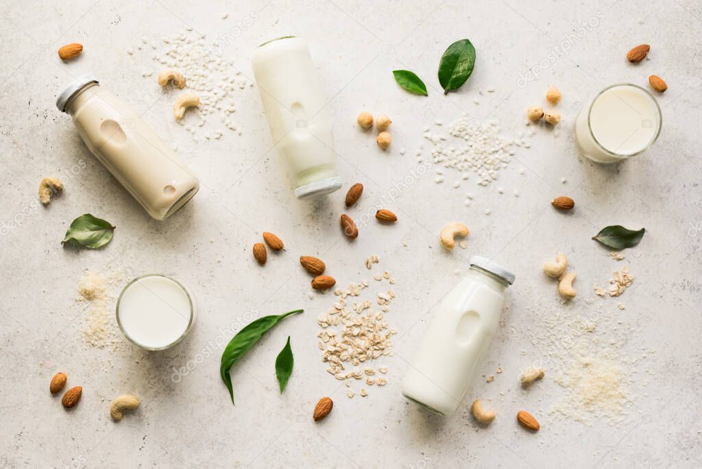 Vegan plant based milk and ingredients, top view, copy space. Various dairy free, lactose free nut and grains milk, substitute drink, healthy eating.