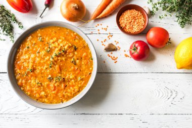 Beyaz arka planda sebzeli kırmızı mercimek çorbası, üst manzara, kopyalama alanı. Geleneksel Türk ya da Arap mercimek ve sebze baharatlı çorba, sağlıklı vejetaryen yemeği..