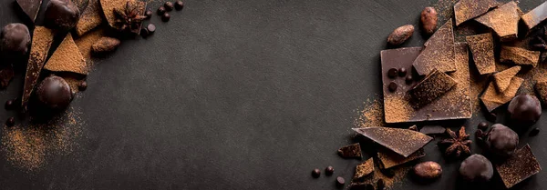 Kara Çikolata Arkaplanı. Çikolata parçaları, trüf mantarı, kakao tozu ve baharatlar siyah masada, üst manzara, boşluk kopyala.