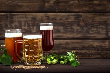 Bardaklarda çeşitli bira fıçıları ve ahşap masada kupalar, fotokopi alanı. Zıpzıp ve maltlı taze bira..