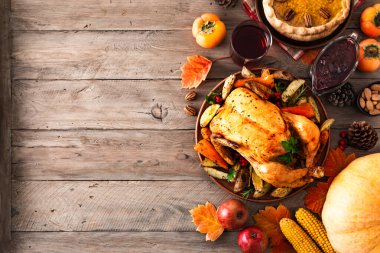 Tavuklu Şükran Günü yemeği, kızılcık sosu, balkabağı turtası, şarap, mevsimlik sebzeler ve ahşap masada meyveler, fotokopi alanı. Geleneksel sonbahar bayramı yemeği konsepti.