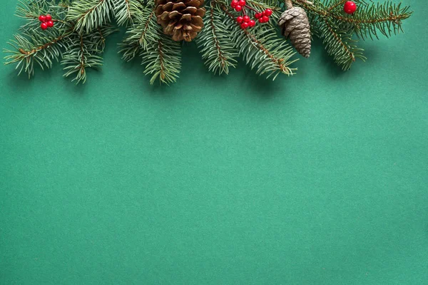 Christmas composition. Christmas decor, pine cones, fir branches on green background. Flat lay, top view, copy space.
