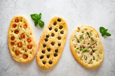 Çeşitli sebze dolgulu İtalyan Focaccia ekmeği. Domatesli, zeytinli, sarımsaklı ve otlu taze pişirilmiş Focaccia, üst görünüm, kopyalama alanı.
