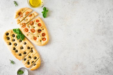 Çeşitli sebze dolgulu İtalyan Focaccia ekmeği. Domatesli, zeytinli, sarımsaklı ve otlu taze pişirilmiş Focaccia, üst görünüm, kopyalama alanı.