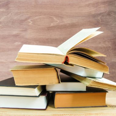 Geri okul ve bilgi kavramı. Ahşap arka plan üzerinde kitap yığını. Önden görünüm