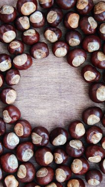 Eski ahşap arka plan üzerinde olgunlaşmış kestane ile kopya alanı kapatın. Hikayeler için üstten görünüm