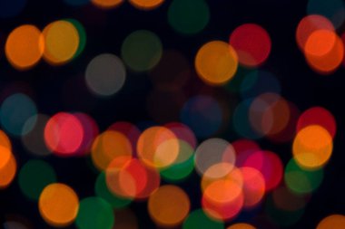 Noel veya Halloween canlı soyut kavram. Parlak noktalar blackground üzerinde kırmızı, sarı, yeşil ve mavi ışık. Bokeh. Yumuşak odak. Yuvarlak şekiller.