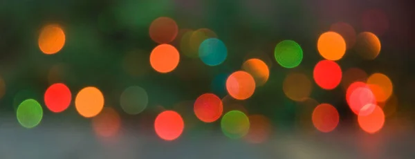 Bright spots of christmas blur glittering lights. Vivid and colorful red, blue, yellow and green christmas tree background of de focused lights,Christmas pattern concept.Bokeh. Soft focus. Web banner