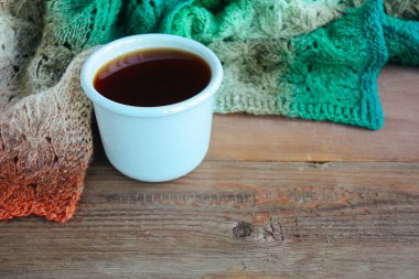 Bir fincan çay rustik örme sıcak sonbahar ya da kış eşarp kahverengi ahşap zemin üzerinde yakınındaki