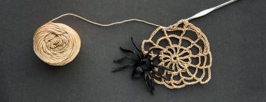 Konu siyah Kağıt arka plan üzerinde siyah lastik örümcek, tığ işi ve pamuk ipliği topu ile tığ işi örümcek ağı. Karanlık halloween Ekim kavramı. Üstten görünüm. Web afiş