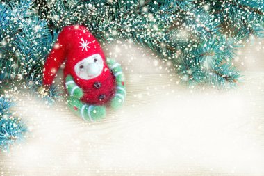 Smowflakes arka plan ile Noel ağacı doğal taze dalları yanındaki şirin renkli Noel oyuncak elf. Üstten görünüm... Kopya alanı