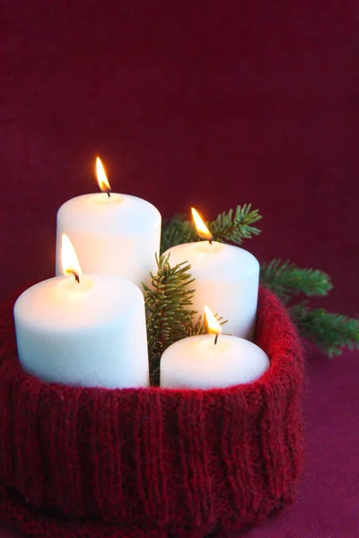 Τέσσερα Λευκά Χριστούγεννα Κεριά Ένα Καίγοντας Φλόγα Ένα Χειροποίητο Πλεκτό — Φωτογραφία Αρχείου